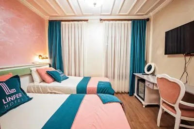 a hotel room with two beds and a television at Linfer Hotel Taksim in Istanbul