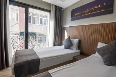 a hotel room with two beds and a window at The Omiya Hotel in Istanbul