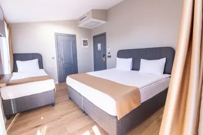 a hotel room with two beds and a window at The Omiya Hotel in Istanbul