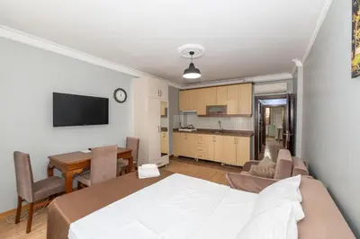 a bedroom with a bed and a table and a kitchen at Terra Apart Taksim in Istanbul