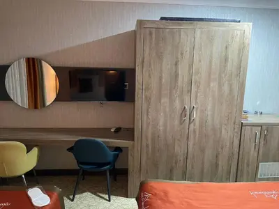 a room with a wooden cabinet and a desk with a mirror at Marrakeschotel in Tuzla