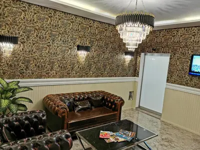 a living room with a leather couch and a chandelier at Marrakeschotel in Tuzla