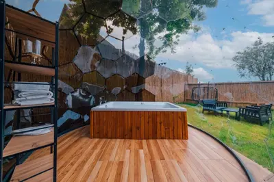 a hot tub on a deck with a wall at Kurtköy Park Bungalov Evleri in Sakarya