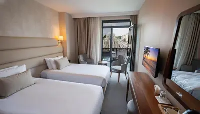 a hotel room with two beds and a balcony at Istanbul Midpoint Hotel in Istanbul
