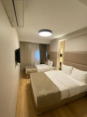 a hotel room with two beds and a television at Otel Yenikapı in Istanbul