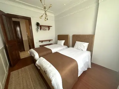 a bedroom with two beds and a chandelier at Botter Dream House in Istanbul