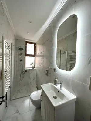 a white bathroom with a sink and a mirror at Botter Dream House in Istanbul