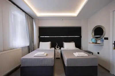 two beds in a hotel room with a mirror at Carvan hotel in Istanbul