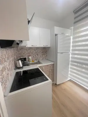 a kitchen with white cabinets and a white refrigerator at Two Bedroom King Suite IH19 in Esenyurt