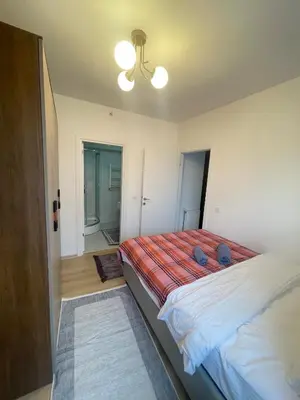 a bedroom with a bed with a red and white blanket at Two Bedroom King Suite IH19 in Esenyurt