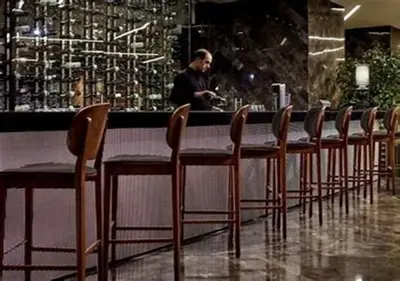 a row of chairs at a bar with a man in the background at Prime Istanbul in Istanbul