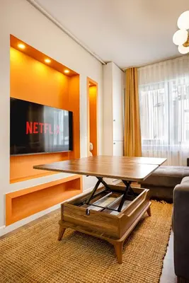 a living room with a table and a tv at Port Galata Suites in Istanbul