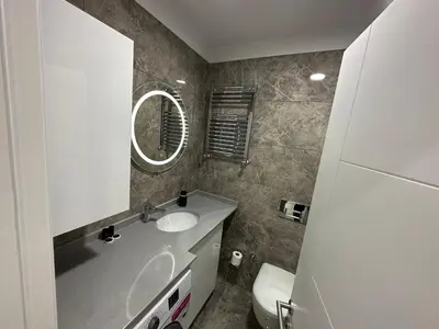 a bathroom with a sink and a mirror and a toilet at Rose Plus Residence in Istanbul