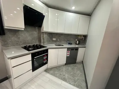 a small kitchen with white cabinets and a stove at Rose Plus Residence in Istanbul