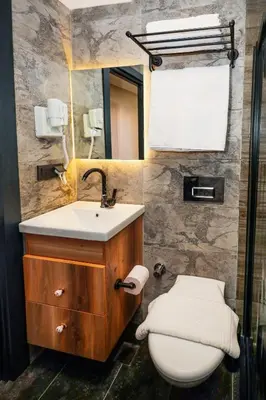 a bathroom with a sink and a toilet and a mirror at Galata Master Hotel in Istanbul