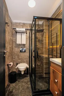 a bathroom with a toilet and a glass shower at Galata Master Hotel in Istanbul