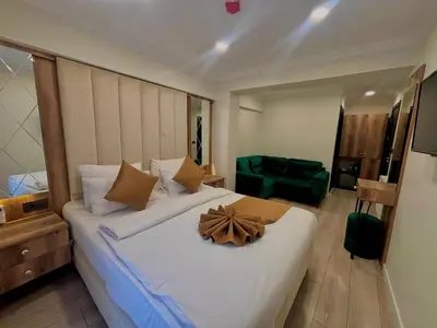 a bedroom with a large white bed with a wooden headboard at Galata Master Hotel in Istanbul