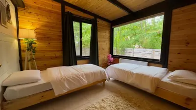 two beds in a wooden room with a window at Pentalow Cabin in Kocaeli