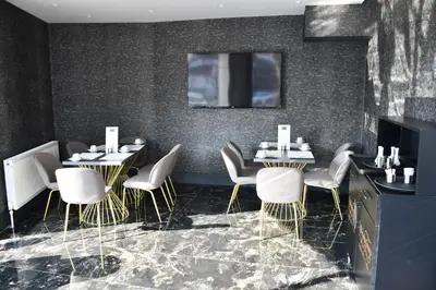 a dining room with two tables and white chairs at Hmz LUXURY HOTEL in Çekmeköy
