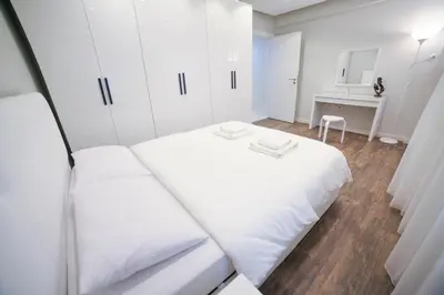 a white bedroom with two beds and a desk at Modern Super Chic Duplex with a Terrace at the heart of city! in Istanbul