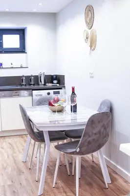 a kitchen with a white table and chairs at Modern Super Chic Duplex with a Terrace at the heart of city! in Istanbul