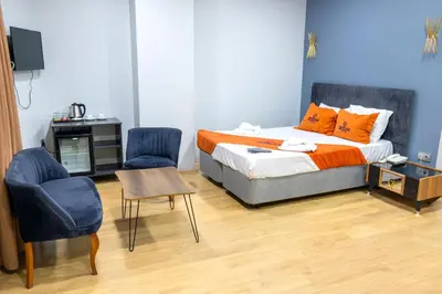 a bedroom with a bed with two chairs and a table at ZOOM HOTEL in Istanbul