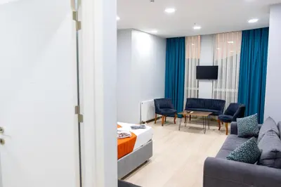a living room with a couch and chairs and a tv at ZOOM HOTEL in Istanbul