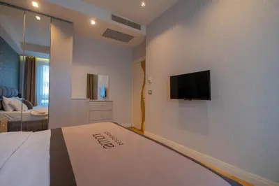 a bedroom with a bed and a flat screen tv on the wall at Ar-mo-ni in Istanbul