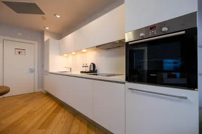 a kitchen with white cabinets and a black microwave at Ar-mo-ni in Istanbul