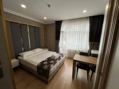 a bedroom with a bed and a table and a desk at H&L Suites in Istanbul