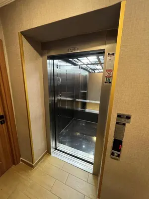 an elevator with a glass door in a building at H&L Suites in Istanbul