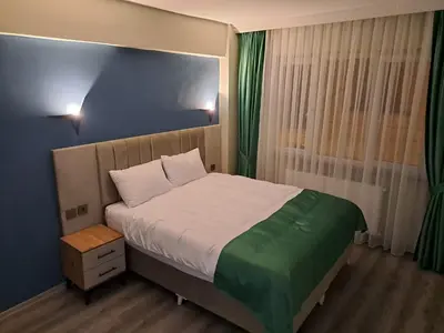 a bedroom with a large bed and green curtains at Taksim Nida Flats in Istanbul