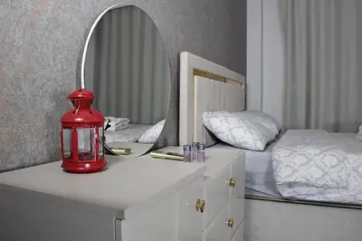 a red lamp on a white dresser with a mirror at Solo Suites Hotel in Istanbul
