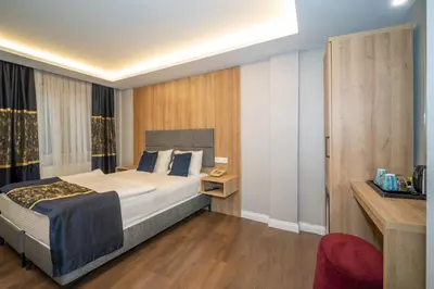 a bedroom with a large bed and a red chair at Hotel Martin in Istanbul