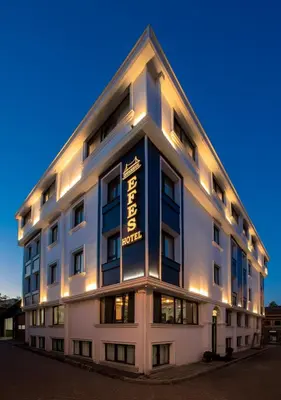 a large white building with a sign on it at İstanbul Efes Hotel in Istanbul
