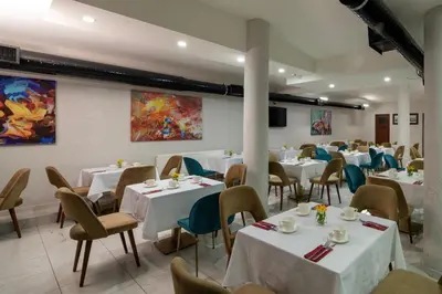 a dining room with white tables and chairs at İstanbul Efes Hotel in Istanbul