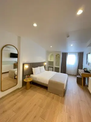 a hotel room with a bed and a large mirror at Meshk Airport Hotel in Arnavutköy