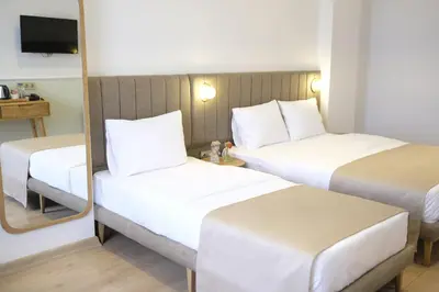a hotel room with two beds and a mirror at Meshk Airport Hotel in Arnavutköy