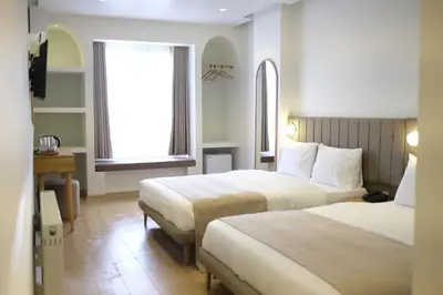 a hotel room with two beds and a window at Meshk Airport Hotel in Arnavutköy