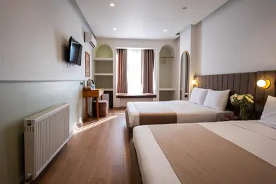a hotel room with two beds and a window at Meshk Airport Hotel in Arnavutköy