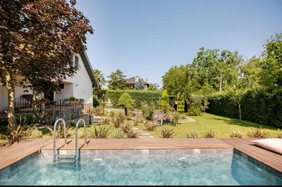 a swimming pool with a wooden deck and a yard at Villa Base Kırkpınar Detached Villa with pool in Sapanca