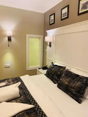 a bedroom with a bed with two pillows on it at Olympos Garden Hotel in Istanbul