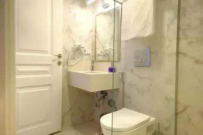 a bathroom with a sink and a toilet and a mirror at Olympos Garden Hotel in Istanbul