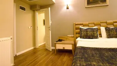 a room with two beds and a door to a bedroom at Olympos Garden Hotel in Istanbul