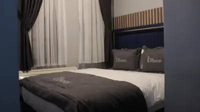 a bedroom with a bed with a black blanket on it at İstasyon Otel in Boyalık