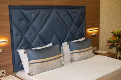 a bed with a blue headboard in a room at Velmore Hotel & Spa in Kestel
