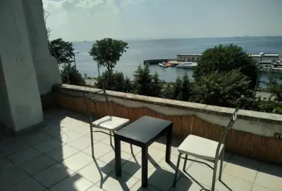 two chairs and a table on a balcony overlooking the water at Ceylan Köşk Apartman in Istanbul
