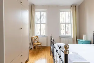 a bedroom with a bed and a chair and two windows at Warm Cozy Charming 2BD2Bath GalataTower Gem! #256 in Istanbul