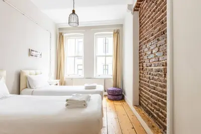 a bedroom with two beds and a brick wall at Bright Charming 2BD15Bath GalataTower Home! #257 in Istanbul