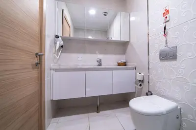 a white bathroom with a toilet and a sink at Mardy Hotel Ataturk Airport in Istanbul
